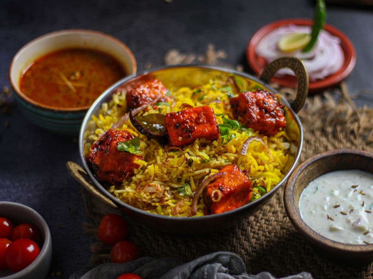Paneer biryani with chargrilled paneer cubes, served with raita and salan